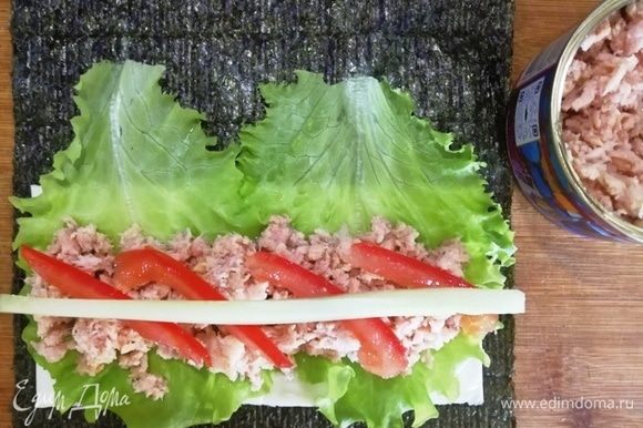 На листья салата в первом случае выкладываем салатный тунец (он более нежный по текстуре и более соленый). На тунец кладем помидор и огурец. Сворачиваем рулетом.