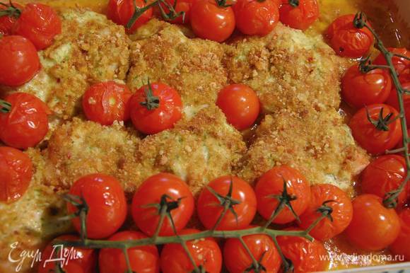 Запекать курицу в разогретой духовке 20 минут, затем добавить в форму помидоры на веточках и запекать все до готовности.