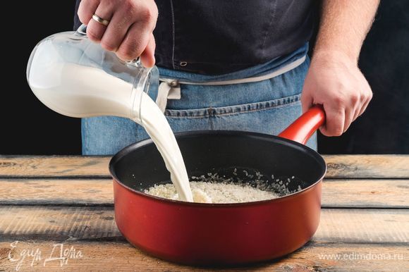 Добавьте подогретое молоко и варите рис 5–7 минут.