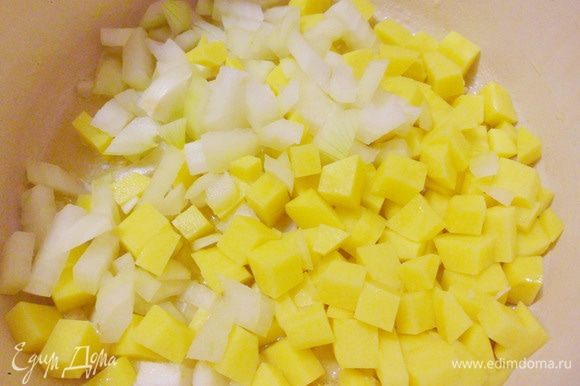 Высыпаем нарезку из картофеля, лука и чеснока в кастрюлю. Обжариваем эту смесь до тех пор, пока лук не станет прозрачным.