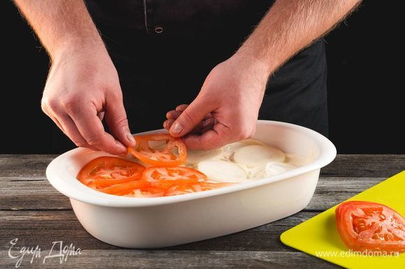 Выложите слой из колец лука и кружков помидора. Посыпьте сыром.