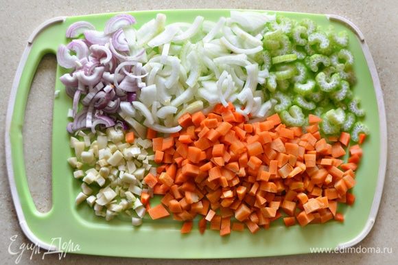 Овощи помыть, очистить. Лук нарезать полукольцами (разрезать еще пополам), морковь — мелкими кубиками, чеснок крупно порубить, сельдерей нарезать полукольцами.