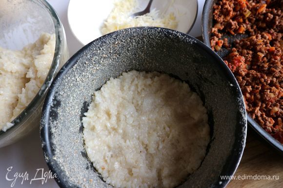 Духовку разогреть до 190°C. Неразъемную форму смазать сливочным маслом (5 г), посыпать панировочными сухарями. Положить на дно формы слой риса в палец толщиной.