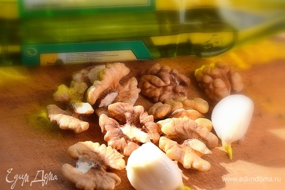 Готовим заправку: скалкой измельчаем грецкие орехи, натираем мелко чеснок, смешиваем с оливковым маслом и добавляем соевый соус.