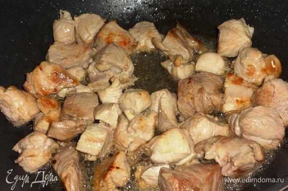 В сковороде разогреть растительное масло и обжарить на нем свинину до румяной корочки, помешивая.