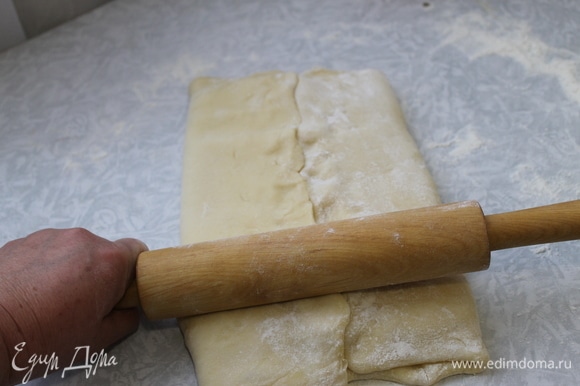 Заверните масло в тесто, защипните края. После этого приступаем к слоению. Аккуратно скалкой надавливая на пласт по всей длине прямоугольника, раскатываем его. Толщина пласта должна получиться около 2 см.