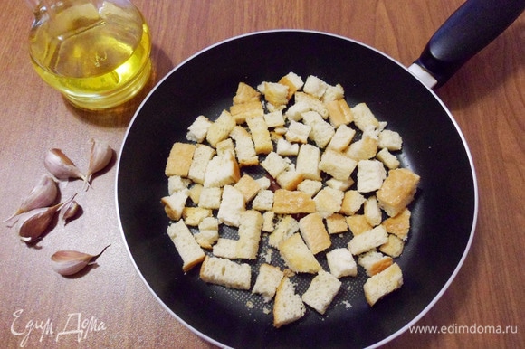 Нарезать на кусочки подсохший хлеб (можно использовать покупные несладкие сухарики). Поджарить сухарики на растительном масле вместе с зубчиками чеснока до золотистого цвета.