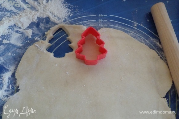 Далее раскатываем тесто в пласт толщиной 0,5 см. Формой для печенья вырезаем елочки.
