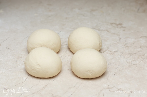 Разделите тесто на 4 части, придайте им форму шара и оставьте на 5 минут, накрыв кухонным полотенцем. После отдыха тесто будет легче раскатываться.