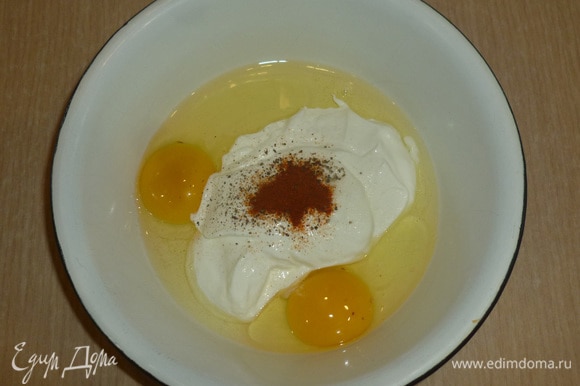 В миску разбить яйца, добавить сметану, соль, перец и паприку. Размешать венчиком до однородности.