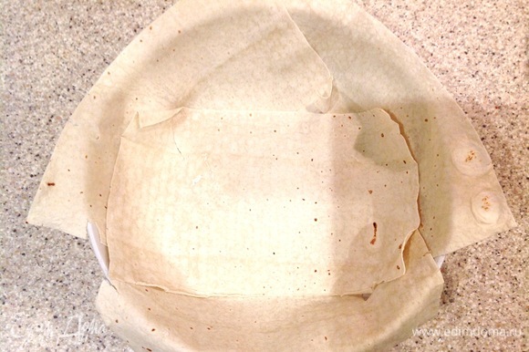 Разогреваю духовку до 180°C. Круглую форму застилаю лавашом (можно заменить на тортилью, рисовые или кукурузные лепешки).