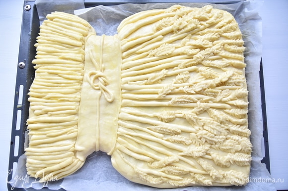 Украсить пирог по желанию. Дать время пирогу на расстойку. Смазать верх пирога яичным желтком и выпекать в духовке, разогретой до 180°C, минут 35–40.