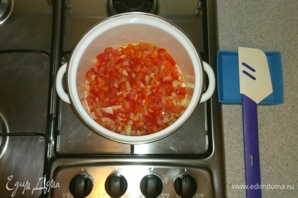 Добавляем оливковое масло в кастрюлю, в которой будем варить суп. После чего выкладываем туда лук, помидор и перец. Перемешиваем все вместе и ставим на маленькую конфорку на средний огонь минут на 5, чтобы овощи чуть-чуть дали сок.