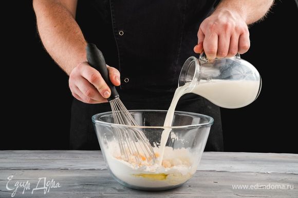 Вымешивайте тесто, постепенно вливая теплое молоко.