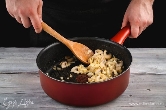 В глубокой сковороде разогрейте оливковое масло, обжарьте лук до прозрачности, добавьте чеснок и грибы. Пожарьте до готовности грибов.