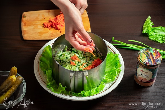 Вареную морковь натрите на терке и выложите в салат. Снова смажьте майонезом.