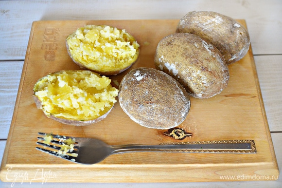 С уже готового картофеля стряхните соль, аккуратно разрежьте картофель пополам, вилкой слегка разомните сердцевину.