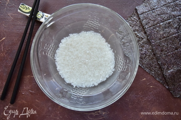 Рис промыть под проточной водой, слегка перетирая руками до светлых вод. Откинуть рис на сито, дать стечь воде и оставить его просохнуть.
