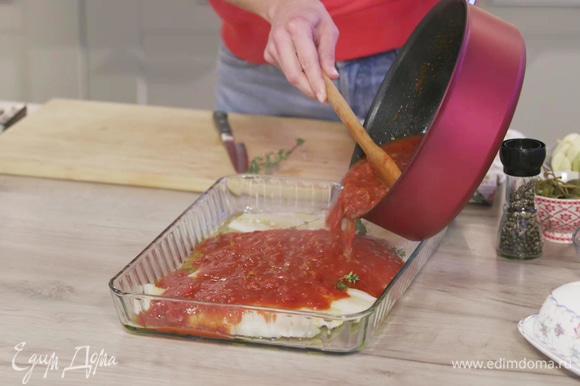 Залить рыбу томатным соусом и выпекать в духовке 5–7 минут.