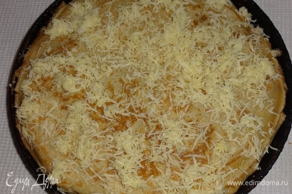 Посыпать верх пирога оставшимся сыром. Поставить пирог в горячую духовку (210–220°C) на 10 минут.