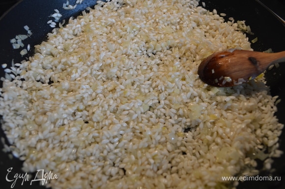 Всыпать рис и обжарить его, помешивая, пару минут.