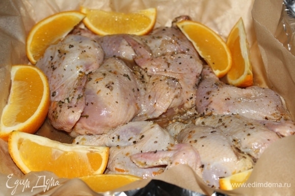 Выложила в форму для запекания, вылила сок апельсина и лимона. Оставшийся апельсин нарезала дольками и выложила рядом с цыплятами.