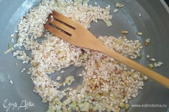 Всыпать рис для ризотто. Перемешать, чтобы рис пропитался ароматным маслом. На соседней конфорке довести до кипения бульон. Куриный можно заменить на овощной.