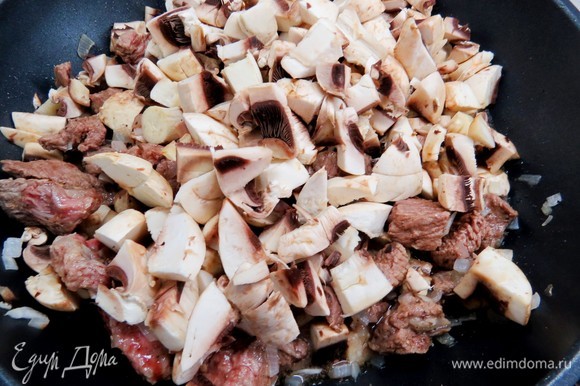 Тем временем нарезать грибы небольшими пластинами, добавить в сковороду к луку и мясу, немного обжарить.