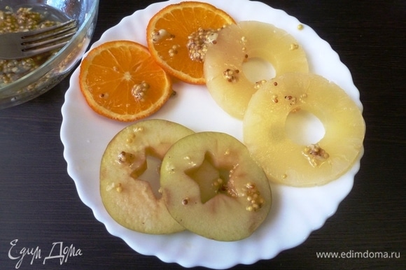 Нарезать апельсин и яблоко на кольца. У яблок вырезать сердцевину с косточками. Смазать кольца фруктов приготовленным маринадом.