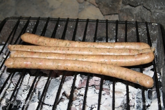 Колбаски обжарить на решетке на мангале до румяных полосочек.