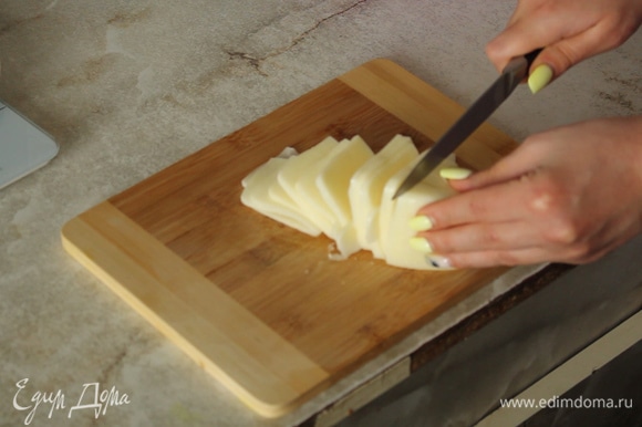 Нарезаем тонкими ломтиками сыр.