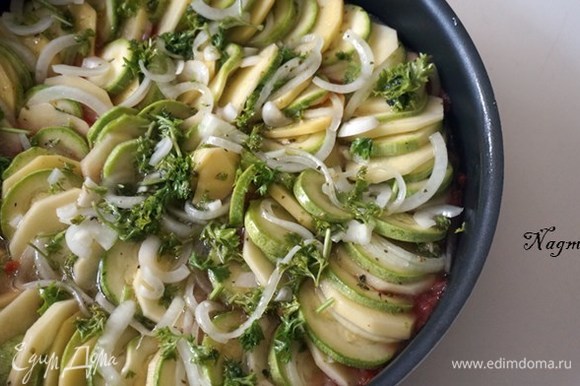 Разложить картофель, цукини и нарезанный лук на сковороде в круговые ряды, чередуя овощи.