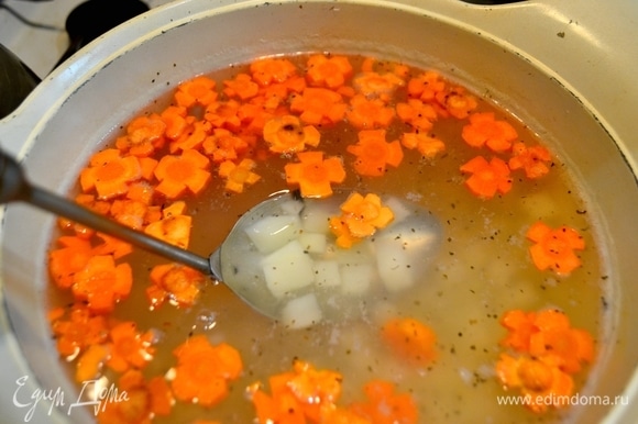 Воду вскипятить, добавить нарезанную кубиком картошку, морковь, нарезанную в форме цветочков, специи, соль по вашему вкусу.