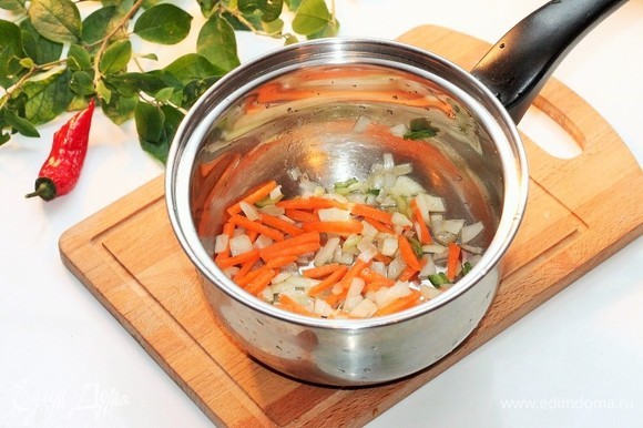 На чесночном масле обжарить лук до прозрачности, затем добавить морковь и пассеровать овощи.