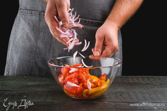 Нарежьте мякоть перцев, помидоров и красный лук, соедините в салатнике.