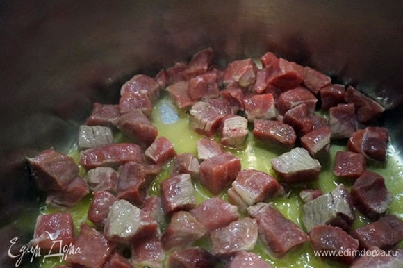 В кастрюле (в казане) разогреть топленое или сливочное и растительное масло. Добавить кусочки мяса и обжарить в течение 5 минут.