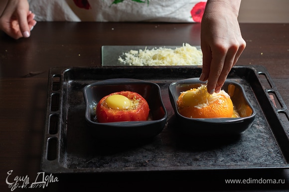 Вылейте белок в помидор. Сверху аккуратно выложите желток. Посыпьте тертым твердым сыром.