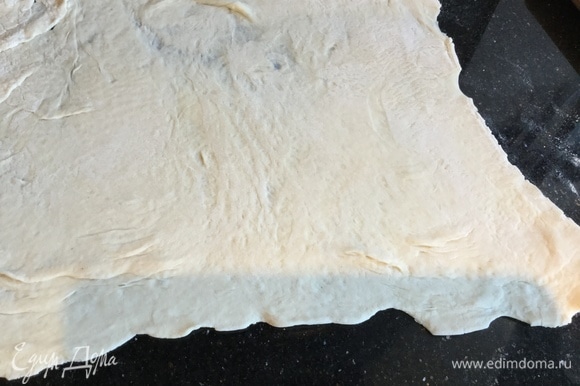 Слоеное тесто раскатайте. Противень застелите бумагой для выпечки и выложите тесто, сделав бортики.