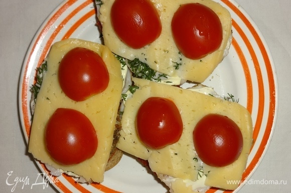 Выложить помидоры на сыр. Поставить бутерброды в духовку или микроволновку на 2–3 минуты для расплавления сыра.