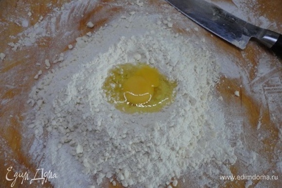 Собрать горкой, добавить сметану и яйцо. Быстро замесить тесто, завернуть его в пищевую пленку и положить в холодильник на 30 минут.