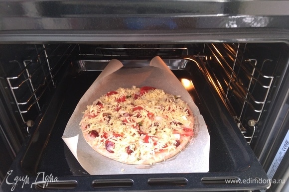 Оставьте в духовке на режиме «Пицца» где-то при температуре 175°C на 20 минут. Если режима такого нет, то просто на любом, где тесто будет готовиться со всех сторон.
