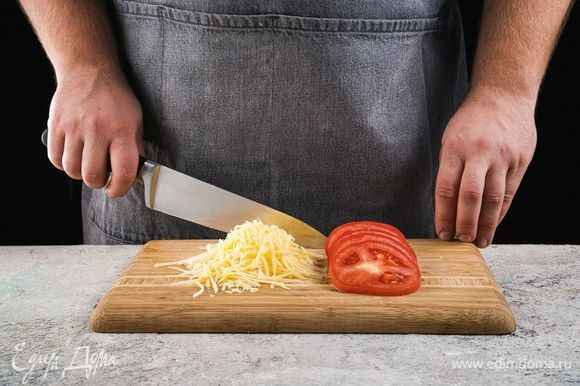 Нарежьте помидоры кружочками, сыр натрите на крупной терке.