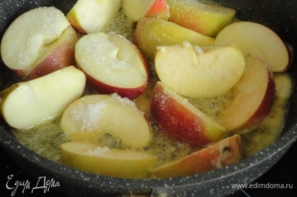 Яблоки вымыть, разрезать каждое на 8 долек и удалить сердцевину с семенами. На сковороде растопить оставшееся сливочное масло, положить туда яблоки, посыпать сахаром и при постоянном помешивании жарить на сильном огне 10 минут.