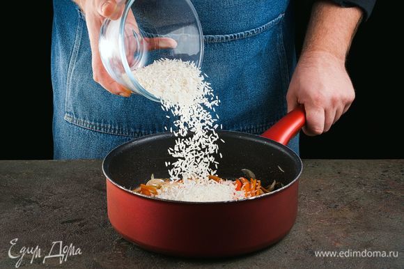 Добавьте промытый рис и обжаривайте еще 3 минуты.