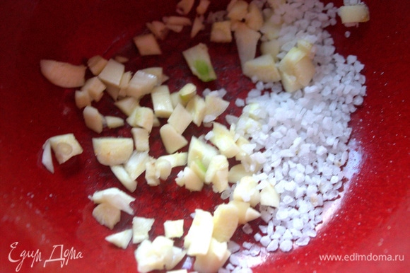 В ступку или пиалку положить измельченный чеснок, насыпать морскую соль.