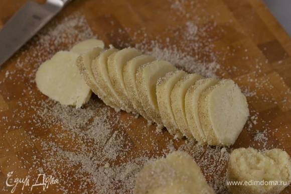 Оставшийся ванильный сахар высыпать на рабочую поверхность и прокатать колбаску из теста, так чтобы она покрылась сахаром. затем острым ножом нарезать тесто на кружки толщиной полсантиметра.