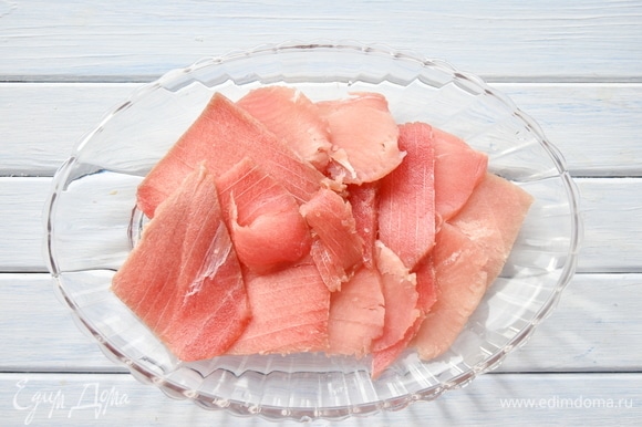 Филе тунца, не размораживая до конца, нарезать тонкими слайсами, разложить на блюде.