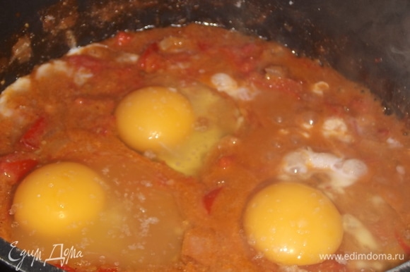 В орехово-томатной смеси сделать углубления. Влить яйца. Посолить. Накрыть крышкой. Тушить до полного схватывания белка. Желток должен оставаться жидким.