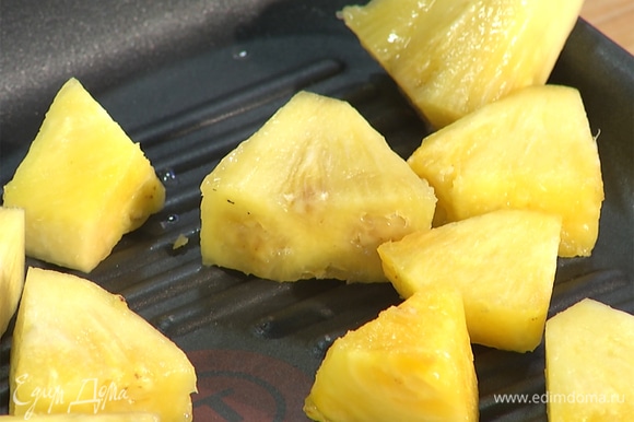 Сильно разогреть сковороду-гриль, обжарить ананасы с двух сторон.