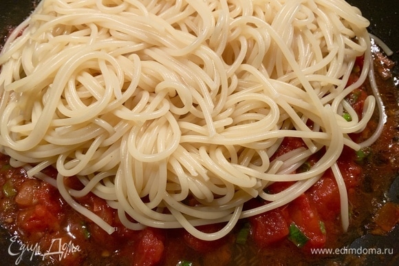 Готовые спагетти кладу на помидорный соус, мешаю и еще пару минут тушу.
